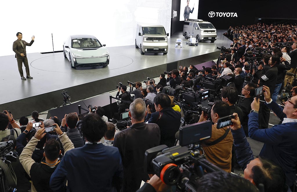 Toyota's President and CEO Koji Sato, left, speaks to the media beside Toyota vehicles on display at Tokyo Mobility Show during a press day at Tokyo Big Sight in Tokyo, on Wednesday, Oct. 29, 2025. 