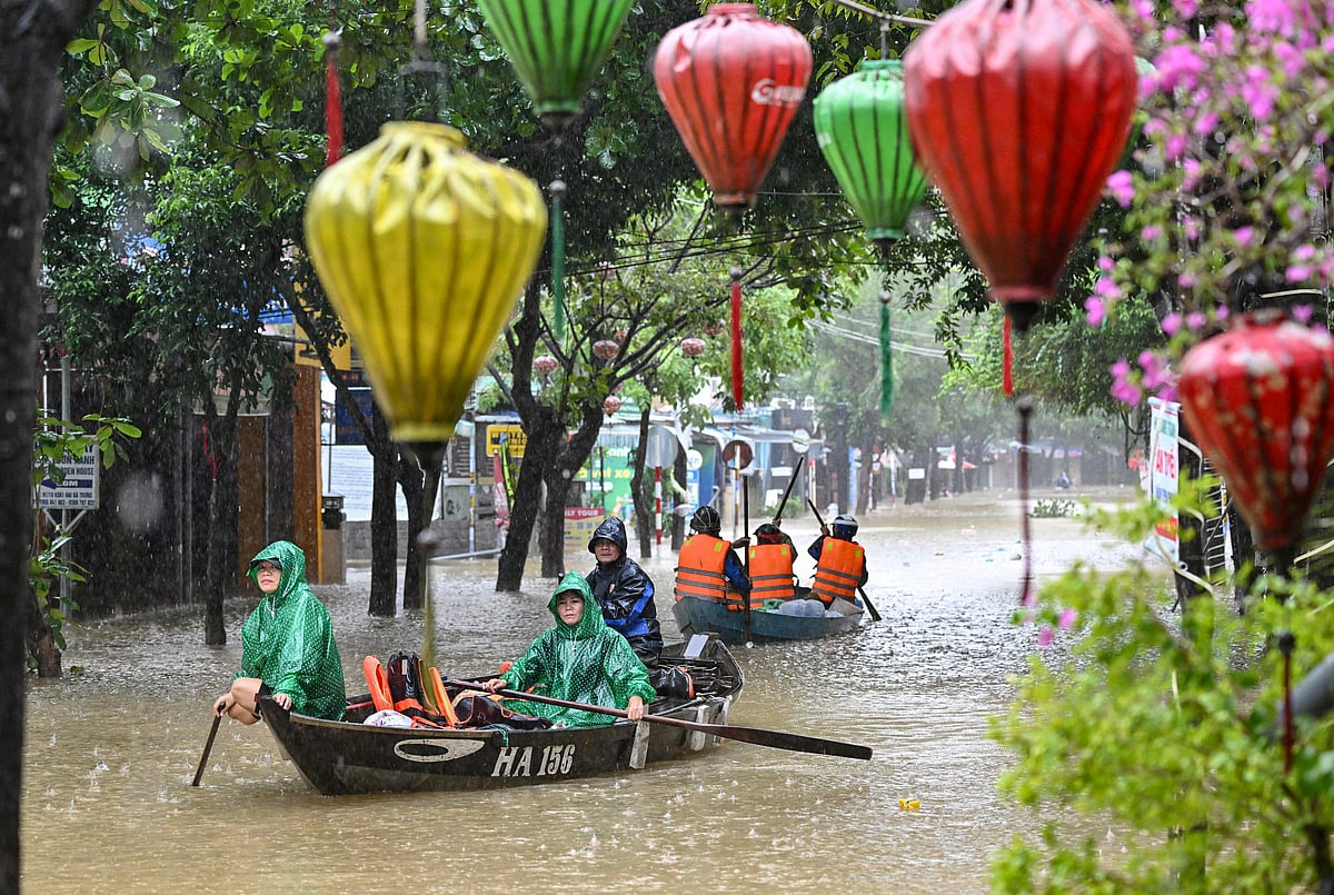 Residents row wooden boats through the submerged streets of Hoi An as floodwaters reach record levels. Vietnam’s coastal provinces have been battered by torrential rain since October 26, with up to 1.7 metres falling in just 24 hours.
