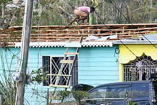 A resident inspects damaged property in the aftermath of Hurricane Melissa in the community of Cave in Westmoreland, Jamaica, on October 31, 2025.