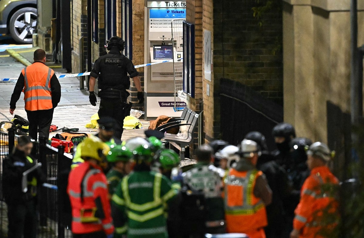 Police and Emergency workers pass a Police cordon outside Huntingdon Station in Huntingdon following a stabbing on a train.