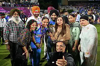 India's captain Harmanpreet Kaur (C) poses with her family members after winning the ICC Women's Cricket World Cup 2025 one-day international (ODI) final match between India and South Africa at the DY Patil Stadium in Navi Mumbai on November 3, 2025.
