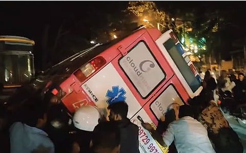 Bystanders trying to lift the ambulance to rescue those trapped beneath.