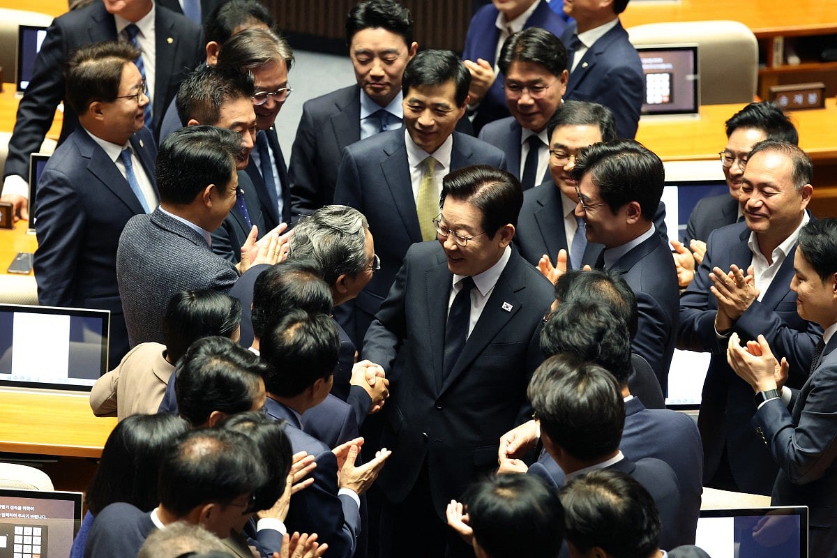 South Korean President Lee Jae Myung (C) leaves after delivering a speech at the National Assembly in Seoul on November 4, 2025.