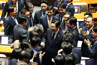 South Korean President Lee Jae Myung (C) leaves after delivering a speech at the National Assembly in Seoul on November 4, 2025.
