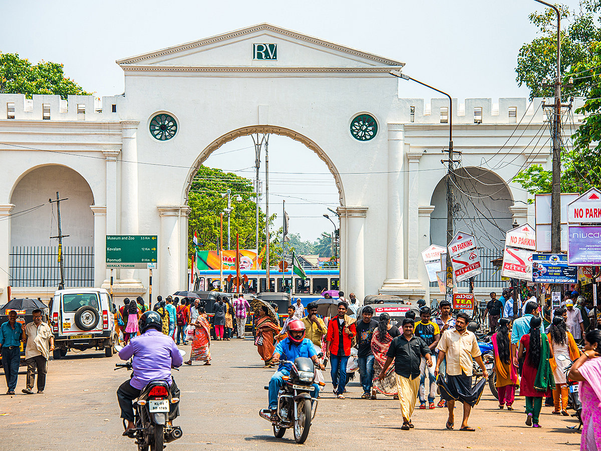 A bustling street scene at the entrance of a colonial-era structure in Thiruvananthapuram, Kerala, India. Kerala has become the first state in India to eradicate extreme poverty.