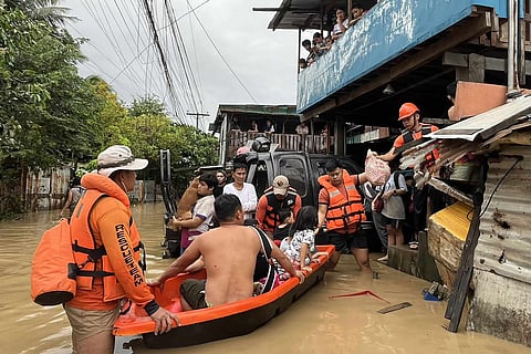 This handout photo taken and released on November 4, 2025 by the Philippine Coast Guard (PCG) shows coast guard personnel evacuating people from their flooded homes following heavy rains brought about by Typhoon Kalmaegi in Cebu province, central Philippines.