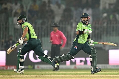 Pakistan's Mohammad Rizwan (R) and Pakistan's Salman Agha run between the wickets during the first one-day international (ODI) cricket match against South Africa at the Iqbal Stadium in Faisalabad on November 4, 2025.