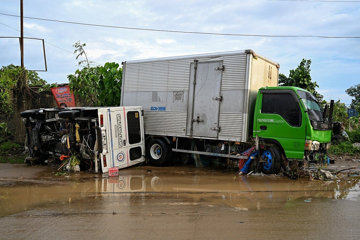 Damaged vehicles are seen along a road in the aftermath of Typhoon Kalmaegi in Mandaue City, Cebu province on November 5, 2025.