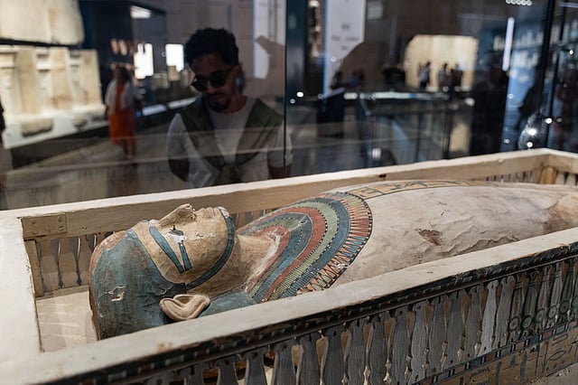 A visitor admires the gilded chariots and jewellery of Tutankhamun — masterpieces of craftsmanship from over 3,000 years ago.