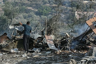 A man stands amid the debris at the site of an Israeli airstrike in the southern Lebanese village of Toura on November 6, 2025.
