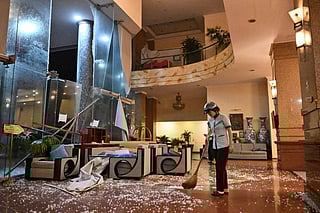 A worker cleans broken glass at a hotel close to Quy Nhon beach as Typhoon Kalmaegi makes landfall in Gia Lai province in central Vietnam on November 6, 2025.