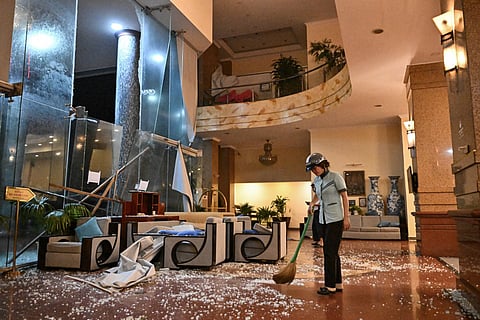 A worker cleans broken glass at a hotel close to Quy Nhon beach as Typhoon Kalmaegi makes landfall in Gia Lai province in central Vietnam on November 6, 2025.