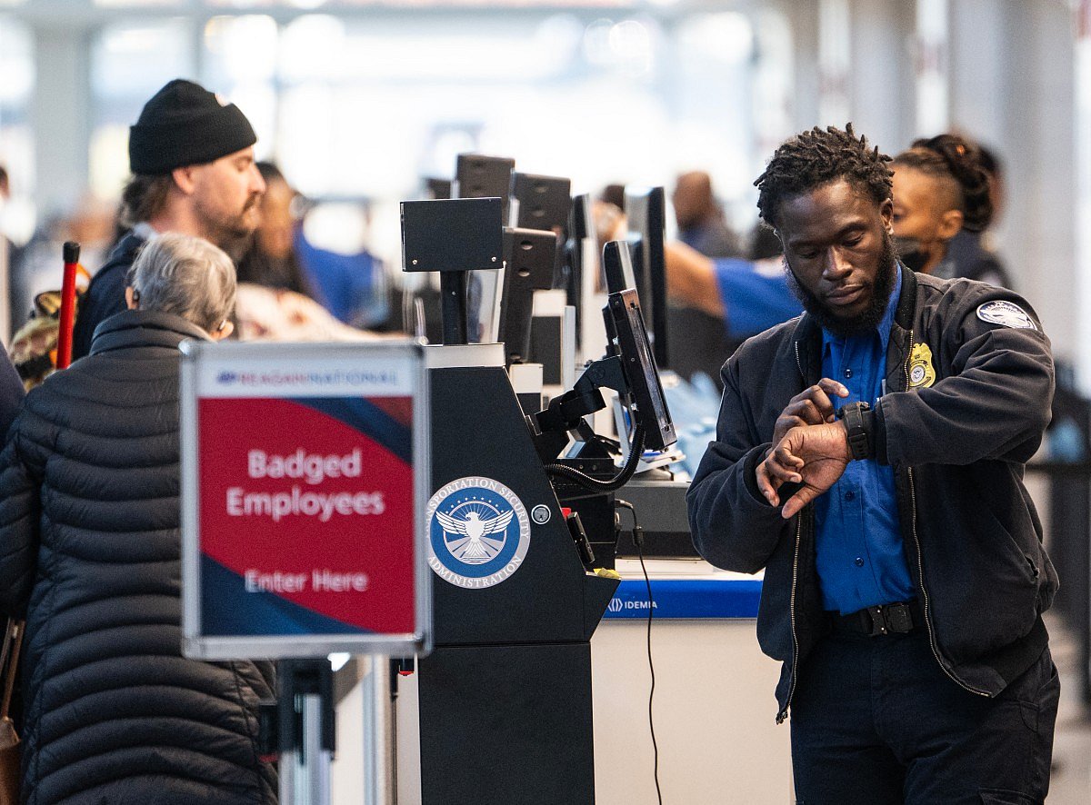 A TSA agent checks his watch while working at a security checkpoint at Ronald Reagan Washington National Airport in Arlington, Virginia on November 7, 2025.