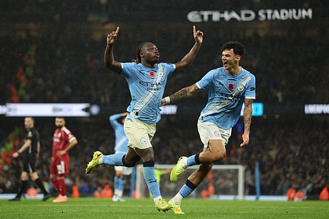 Manchester City's Belgian midfielder Jeremy Doku (L) celebrates scoring their third goal for 3-0 with midfielder Nico O'Reilly (R) during the English Premier League football match against Liverpool at the Etihad Stadium in Manchester, north west England, on November 9, 2025.