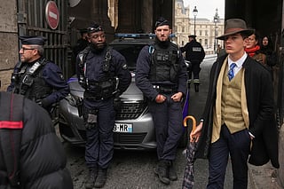 Pedro Elias Garzon Delvaux, right, walks past as police officers block an entrance to the Louvre after thieves carried out a daylight raid on French crown jewels, in Paris, October 19, 2025.