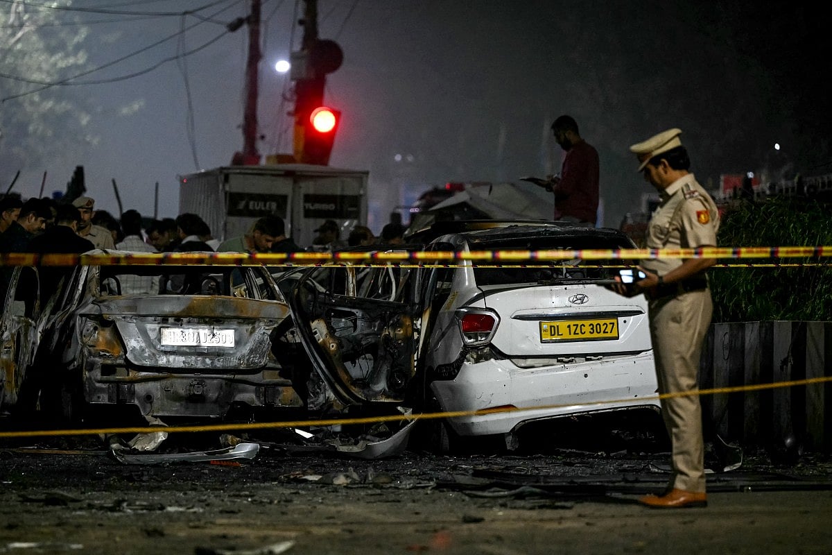 A police personnel inspects charred vehicles at the blast site after an explosion near the Red Fort in the old quarters of Delhi on November 10, 2025.