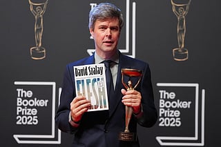Hungarian-British author David Szalay poses for photographers with the trophy after winning the Booker Prize 2025 for his book 'Flesh' during a ceremony at Old Billingsgate in London, Monday, Nov. 10, 2025.