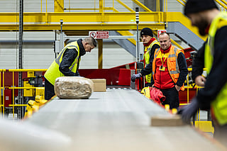Employees put parcels on a line at a DHL warehouse in Lesquin, near Lille, on November 12, 2025.