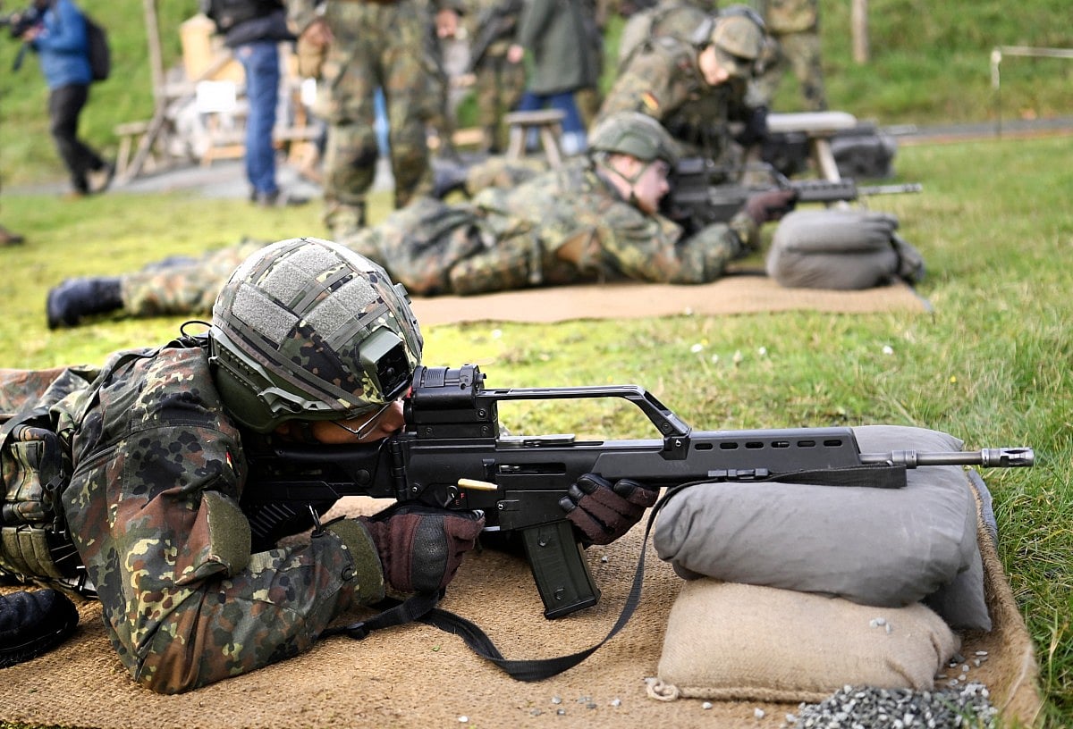 A recruit of the German armed forces Bundeswehr lies on the ground to train shooting with a G36 assault rifle on November 13, 2025 on a military base in Ahlen, western Germany, during a media day about the basic training for Bundeswehr recuits.