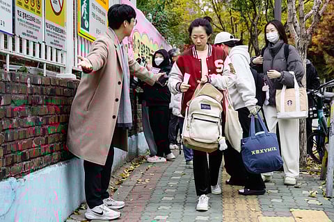 Students arrive for the annual college entrance exam, known locally as Suneung, outside the Gwangnam High School in Seoul on November 13, 2025.