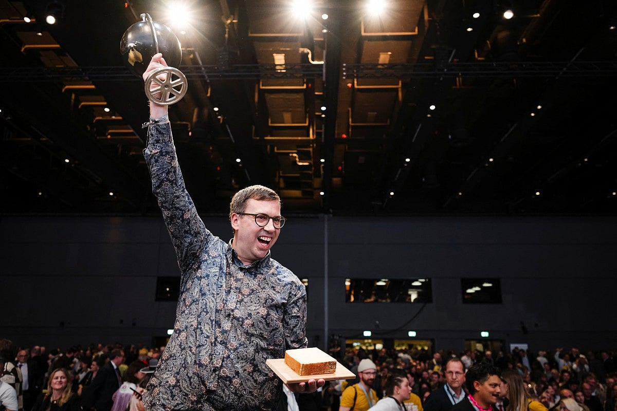 Swiss cheese maker Hitz Pius, from the Vorderfultigen cheese company, raises the trophy after winning the first prize at the World Cheese Awards with a Gruyere AOP special over 18 months cheese, during the 37th edition of the World Cheese Awards, organised by the Guild of Fine Food, on November 13, 2025 in Bern, Switzerland.