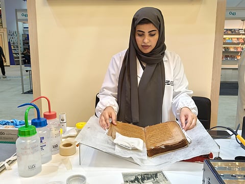 Shaima Alameri, Restoration Specialist at the National Library and Archives (NLA), demonstrating book conservation techniques.