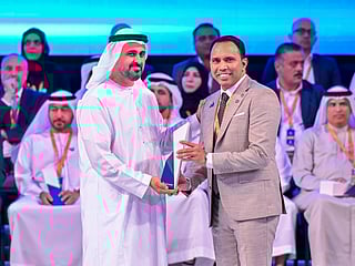 Sheikh Theyab bin Mohamed bin Zayed Al Nahyan presents the Outstanding Workforce Award to Anas Kadiyarakam.