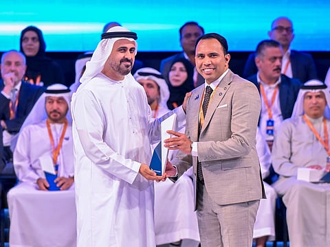 Sheikh Theyab bin Mohamed bin Zayed Al Nahyan presents the Outstanding Workforce Award to Anas Kadiyarakam.