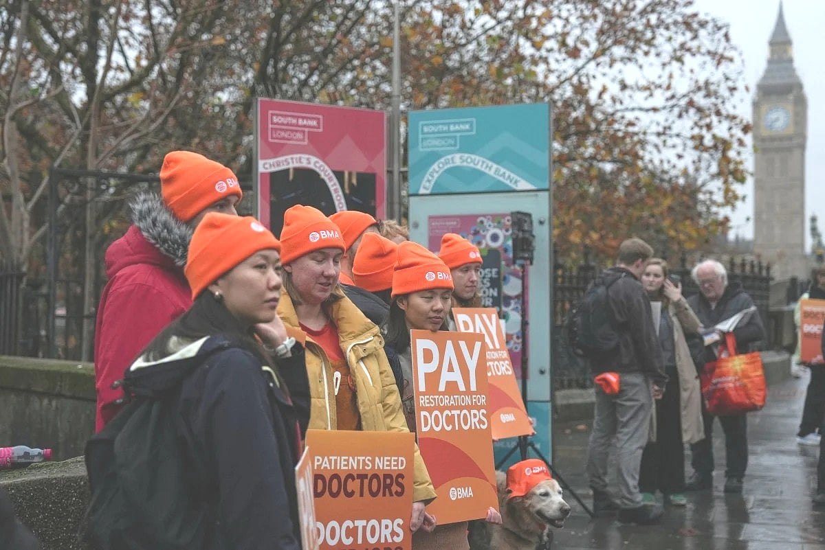Staff members hold placards as they stand on a picket line on the first day of a five-day resident doctors' strike outside St Thomas' Hospital in central London on November 14, 2025.