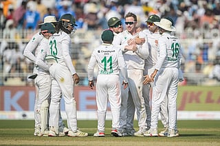 South Africa's Simon Harmer (3R) celebrates with teammates after taking the wicket of India's Kuldeep Yadav during the third day of the first Test cricket match at the Eden Gardens in Kolkata on November 16, 2025.