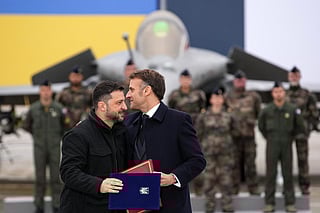 France's President Emmanuel Macron (R) and Ukraine's President Volodymyr Zelensky (L) hug after signing an agreement at the Villacoublay air base, in Velizy-Villacoublay, near Paris on November 17, 2025.