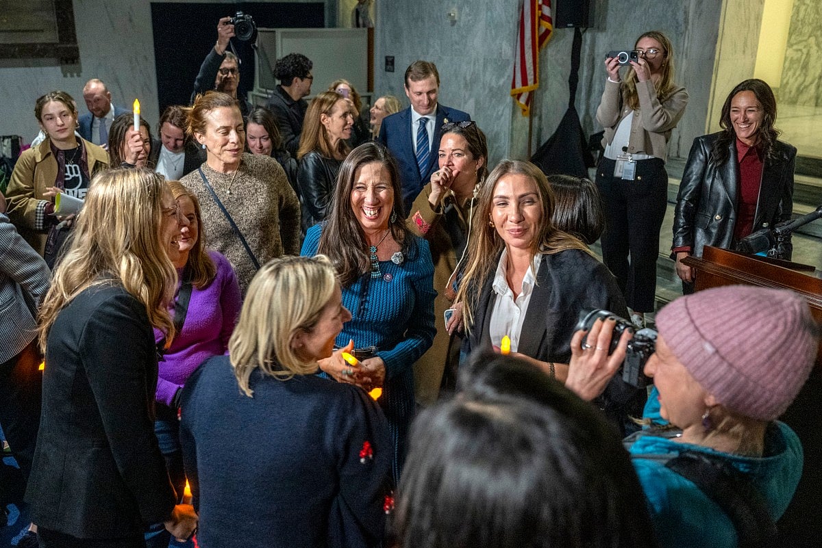 US congresswoman Teresa Leger Fernandez (C), Democrat of New Mexico, celebrates with victims of convicted sex offender Jeffrey Epstein, after announcing to attendees of a candlelight vigil, that the US Senate passed the "Epstein Files Transparency Act" in Washington, DC on November 18, 2025.