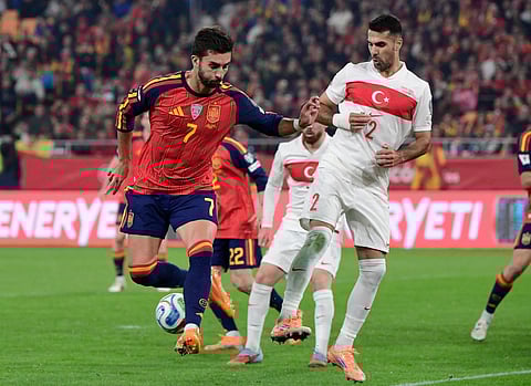 Spain's forward #07 Ferran Torres fights for the ball with Turkey's defender #02 Zeki Celik during the FIFA World Cup 2026 European qualification Group E football match between Spain and Turkey at the Cartuja stadium in Seville on November 18, 2025.