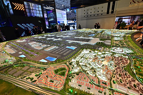 People look at the model of the new Al-Maktoum International Airport during the Dubai Airshow 2025 in Dubai on November 17, 2025.