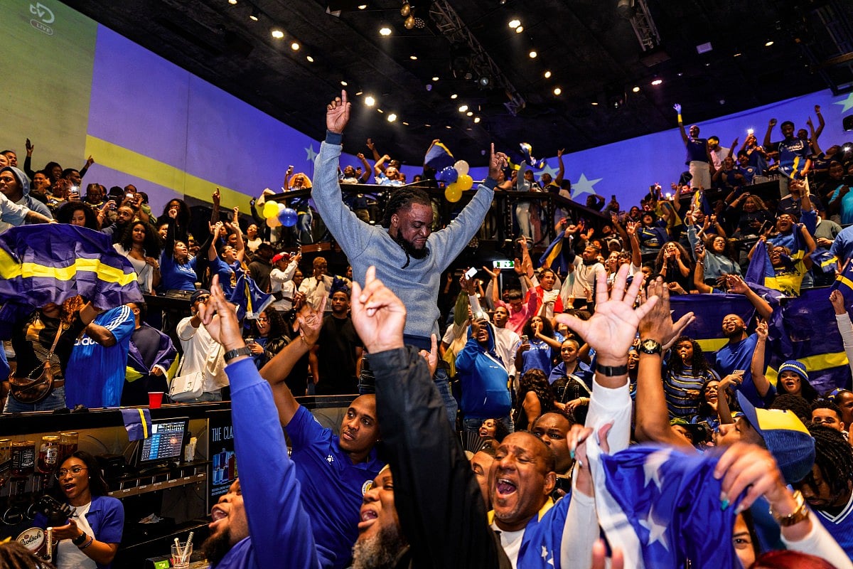 Curacao's supporters celebrate as they watch the FIFA 2026 World Cup qualifier football match between Jamaica and Curacao in a cafe in Rotterdam on November 18, 2025.