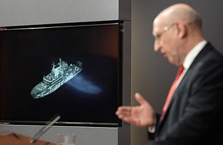 Britain's Defence Secretary John Healey, backdropped by a screen displaying an image of Russian military ship Yantar, operating off the northern coast of Scotland, delivers a speech in the Downing Street briefing room in central London on November 19, 2025.