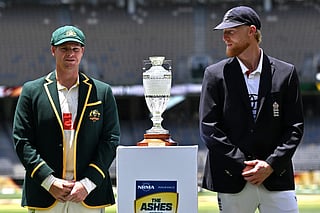 Australia's captain Steve Smith (L) and England's captain Ben Stokes stands next to the Waterford Crystal Ashes trophy at Perth Stadium in Perth on November 20, 2025, ahead of the first Ashes cricket Test match.
