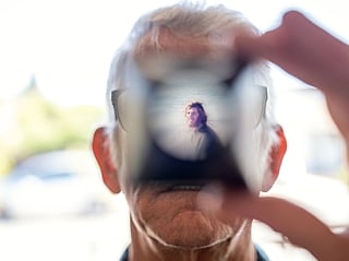 Christy Morrill, 72, who lost decades of memories to autoimmune encephalitis, holds up a viewfinder with a slide film of himself as a college student, Wednesday, Aug. 20, 2025, at his home in San Carlos, Calif. (AP Photo/David Goldman)