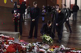 Real Madrid's coach Xabi Alonso (2R) lays a wreath as Trent Alexander-Arnold (L) and Dean Huijsen (2L) and chairman Emilio Butragueno (R) look on at Anfield Stadium in Liverpool on November 3, 2025.