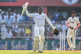 South Africa's Senuran Muthusamy celebrates after scoring a century (100 runs) during the second day of the second Test cricket match against India at the Barsapara Cricket Stadium in Guwahati on November 23, 2025.