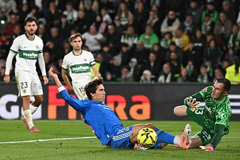 Real Madrid's Spanish forward #16 Gonzalo Garcia and Elche's Spanish goalkeeper #13 Inaki Pena fight for the ball during the Spanish league football match between Elche CF and Real Madrid CF at Martinez Valero Stadium in Elche on November 23, 2025.