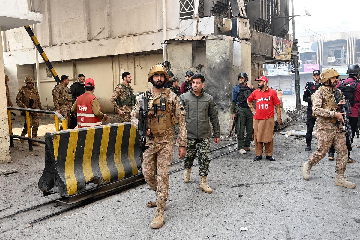 Army personnel inspect the suicide attack site outside the border force headquarters in Peshawar on November 24, 2025.