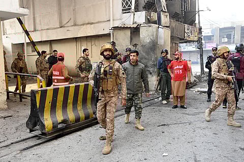 Army personnel inspect the suicide attack site outside the border force headquarters in Peshawar on November 24, 2025.