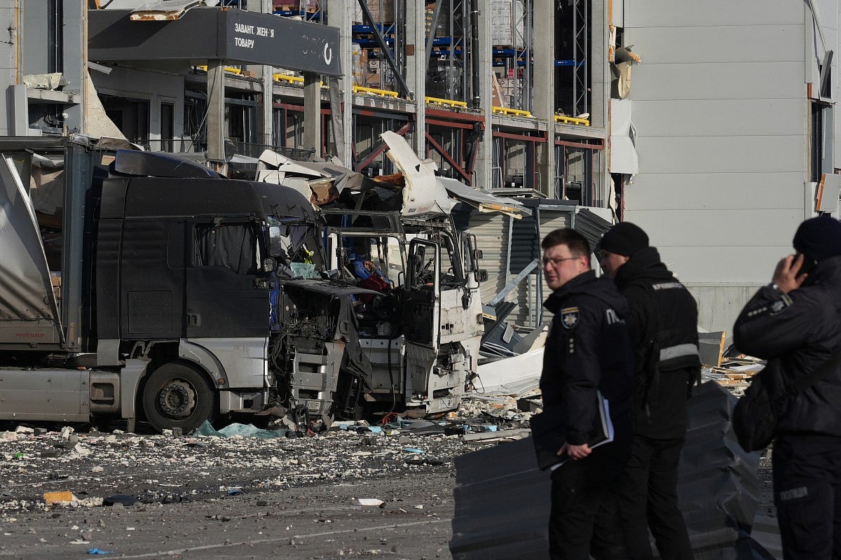 Law enforcement officers work at the site of the heavily damaged logistics hub of the Novus supermarket following Russian missiles and drones strikes in Kyiv on November 25, 2025.