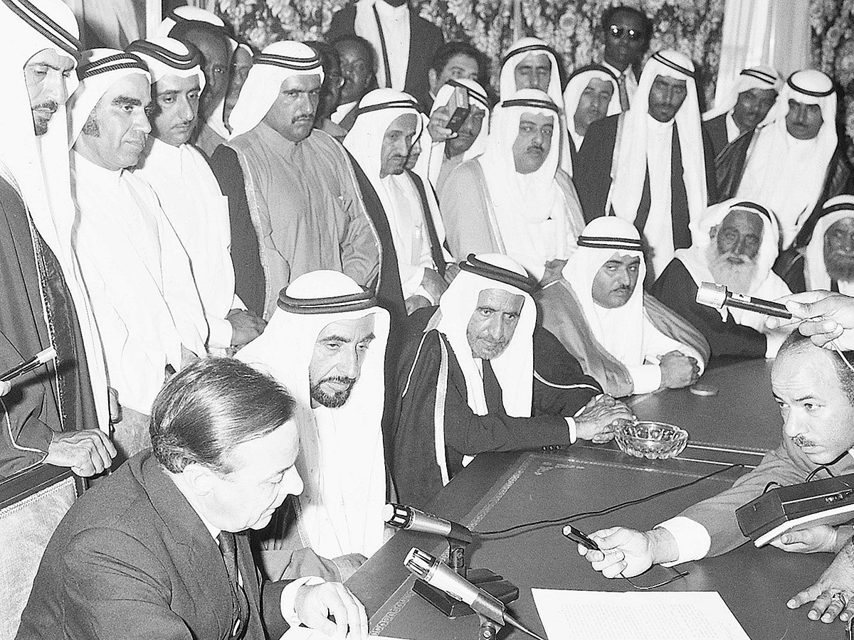 1971. Shaikh Zayed Bin Sultan Al Nahyan, President of the UAE and Ruler of Abu Dhabi with the other rulers of emirates, government representatives and media listen to the British diplomat as he reads the content of the document during the proclamation of union and the declaration of independence.
- WAM