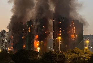 Thick smoke and flames rise as a major fire engulfs several apartment blocks at the Wang Fuk Court residential estate in Hong Kong's Tai Po district on November 26, 2025.