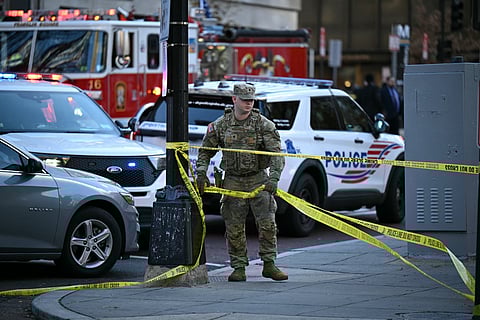 A National Guard soldier secures the area with crime scene tape after a shooting in downtown Washington, DC, on November 26, 2025.
