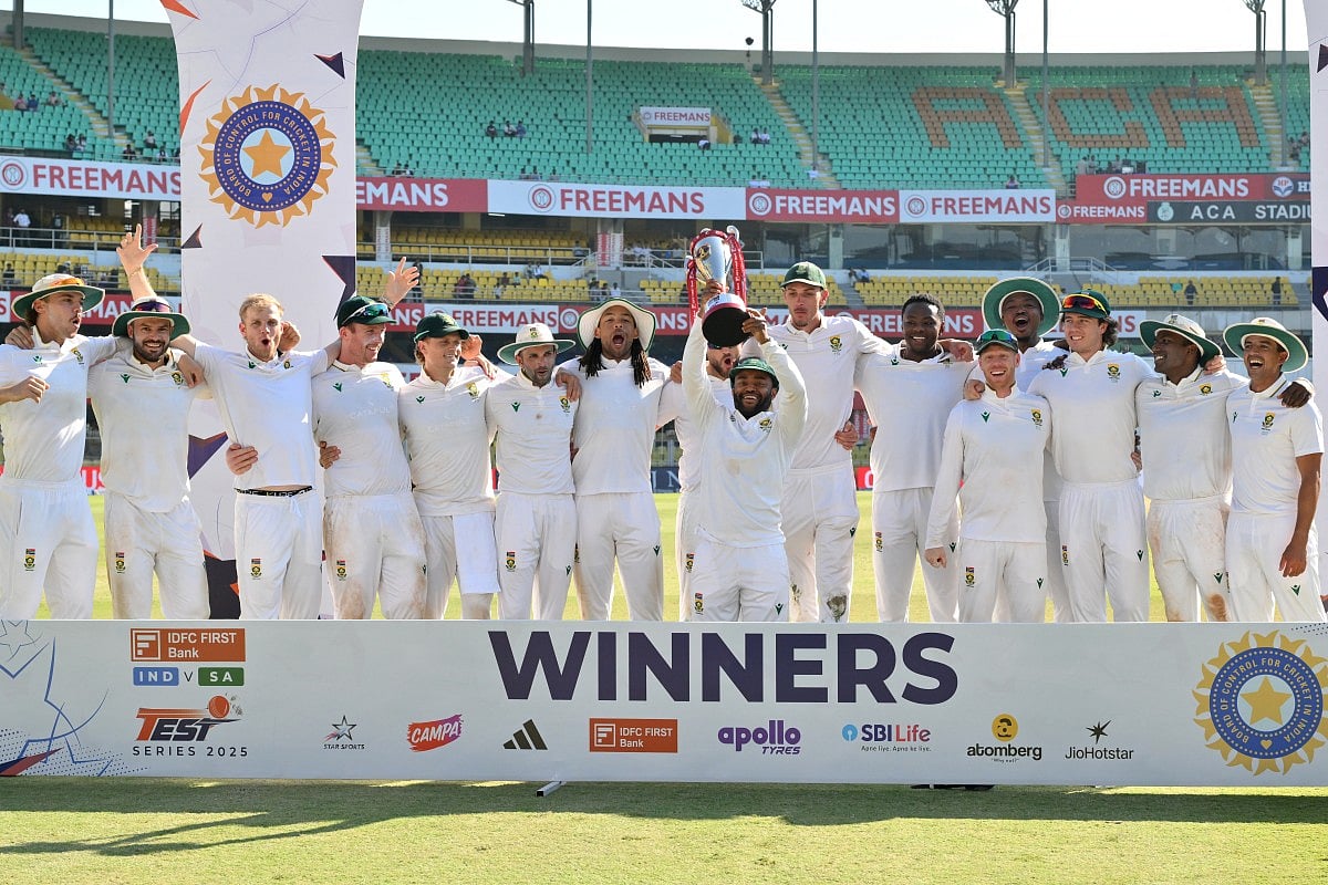 South Africa's players pose with the trophy to celebrate their win in the end of the fifth day of the second Test cricket match against India at the Barsapara Cricket Stadium in Guwahati on November 26, 2025.