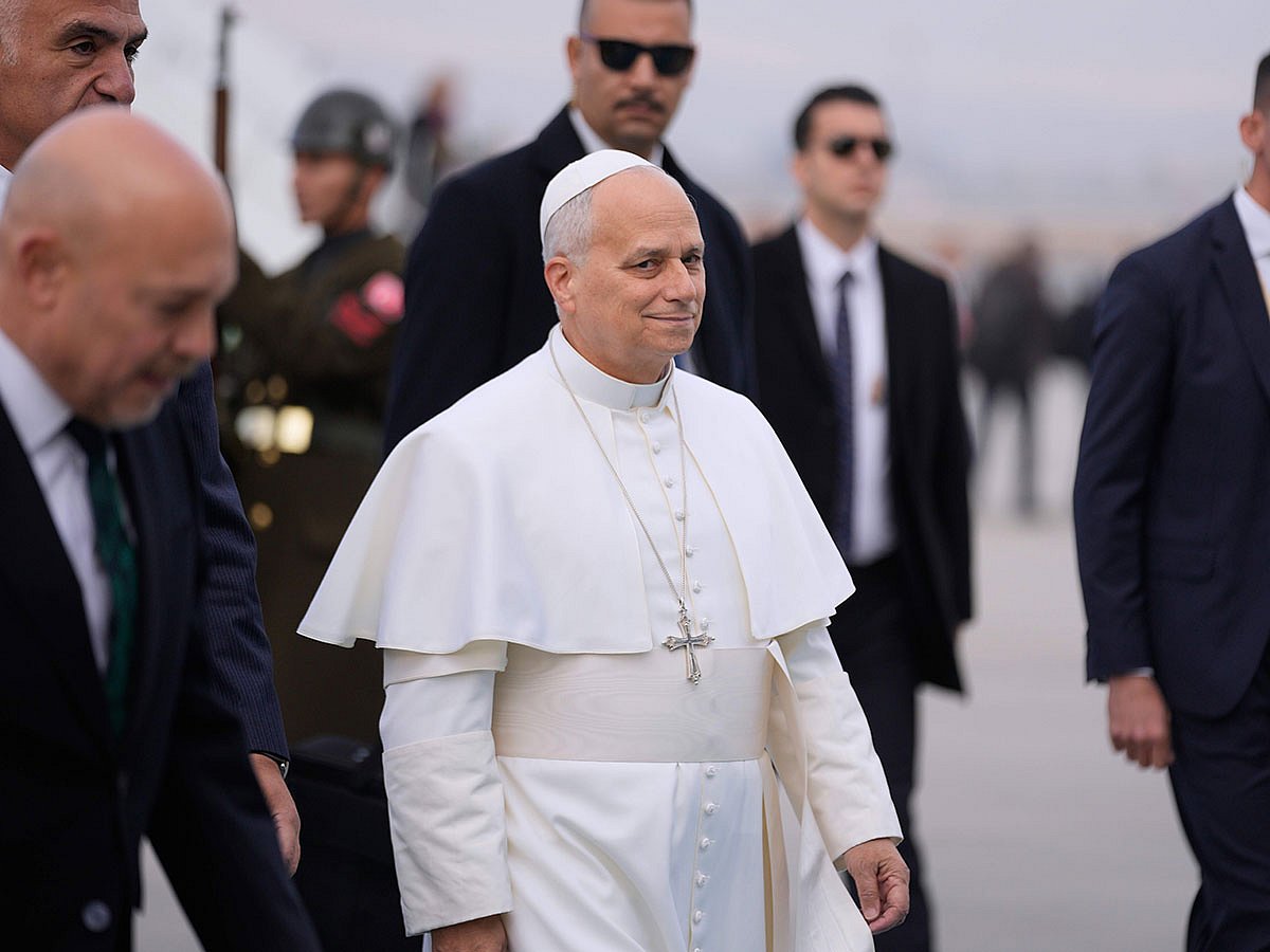 Pope Leo XIV is escorted by security members upon his arrival at Esenboga International Airport in Ankara, Turkey, Thursday, Nov. 27, 2025, marking the beginning of his first foreign trip.