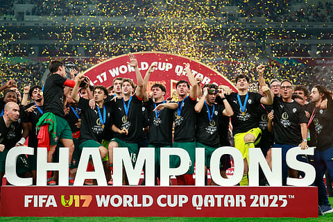 Portugal's players celebrate with the trophy on the podium after the FIFA U17 World Cup final football match between Portugal and Austria at Khalifa International Stadium in Al-Rayyan on November 27, 2025.